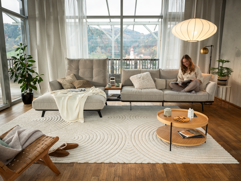 CALTHA_800x600px beiges Sofa CALTHA der ADA Möbelwerke mit lesendem Mädchen